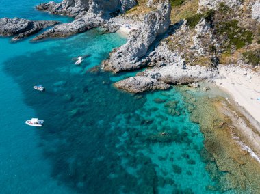 Şeffaf bir denizde yüzen demirli teknelerin havadan görüntüsü. Tüplü dalış ve yaz tatili. Capo Vaticano, Calabria, İtalya. Promontory 'de. Praia Odak Noktası ve Ficara Sahili.