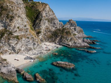Şeffaf bir denizde yüzen demirli teknelerin havadan görüntüsü. Tüplü dalış ve yaz tatili. Capo Vaticano, Calabria, İtalya. Promontory 'de. Praia Odak Noktası ve Ficara Sahili.