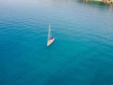Tropea 'da Calabria açıklarında demirlemiş bir yelkenlinin hava görüntüsü. İtalya. Tiren Denizi.