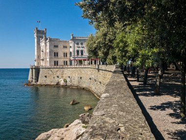 Miramare Kalesi, Trieste, Friuli-Venezia Giulia 'nın tarihi müze ve parkına giriş. 09-05-2021. Deniz kenarında açık havada gezinen insanlar. İtalya