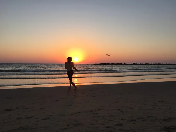 Tel Aviv, Israel, Middle East: a boy playing frisbee on the beach at sunset — Stock Photo, Image