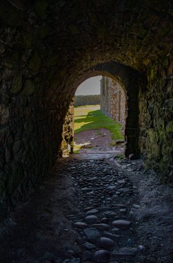 Stonehaven, İskoçya, Birleşik Krallık: Dunnottar Kalesi 'ndeki antik binaların arasından taş kemer, kuzeydoğu kıyısındaki kayalık bir burundaki ortaçağ kalesi.