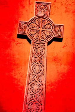 Kırmızı bir zemine taşa oyulmuş Kelt haçı