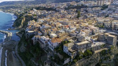 Pizzo Calabro, rıhtım, kale, Calabria, İtalya turizmi. Deniz kenarındaki küçük Pizzo Calabro kasabasının panoramik manzarası. Kayalıklardaki evler. Uçurumun kenarında Murat Aragonese kalesi duruyor.
