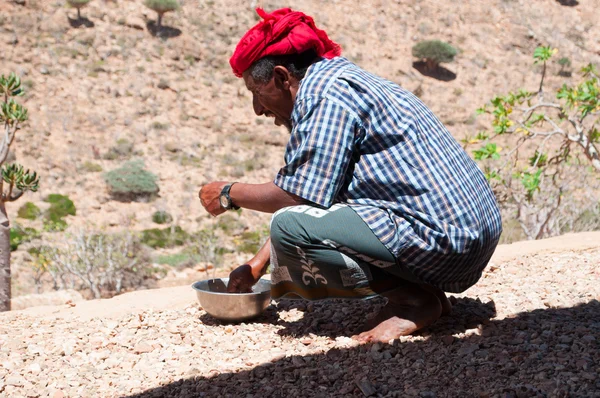 Socotra, Yemen, Middle East: a man with a red turban washing his hands in a bowl in the Dragon Blood trees forest within the protected area of the Homhil Plateau on the island of Socotra, Unesco world heritage site since 2008 for its biodiversity