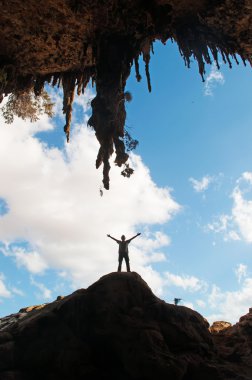 Sokotra, Yemen, Orta Doğu: bir adam bir kayaya Hoq mağaranın girişinde korumalı alan Homhil Yaylası Sokotra Adası üzerinde Unesco Dünya Mirası biyoçeşitliliği için 2008 yılından bu yana ayakta arka ışık silüeti