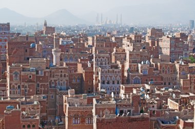 Yemen, Middle East: aerial view of the skyline of the capital Sana'a, Unesco world heritage site, with the Al Saleh Mosque in the fog and the unique palaces and stone tower houses decorated with geometric patterns of fired bricks and white gypsum clipart