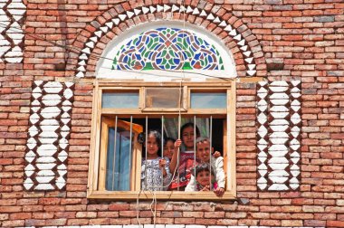 Yemen, Orta Doğu: beş çocuk, erkek ve kız, bir evde bir pencere arkasında ateş tuğla ve eski şehir Sana'a, dünyanın en eski sürekli yaşadığı ve nüfuslu şehir içinde beyaz alçı geometrik desenleri ile dekore edilmiş