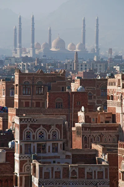 Iêmen, Oriente Médio: vista aérea do horizonte da capital Saná, Patrimônio Mundial da Unesco, com a Mesquita Al Saleh no nevoeiro e os palácios únicos e casas de torre de pedra decoradas com padrões geométricos de tijolos queimados e gesso branco — Fotografia de Stock