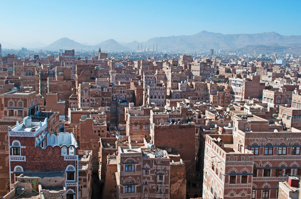 Йемен, Ближний Восток: вид с воздуха на панораму столицы Саны, объект мирового наследия ЮНЕСКО, с его минаретами, мечетями и уникальными дворцами и каменными башнями, украшенными геометрическими узорами из обгоревшего кирпича и белого гипса
