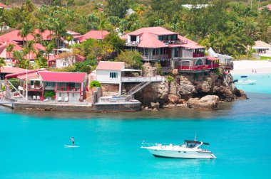 Saint Barthelemy (St Barth, St. Barths veya St. Barts): bir adam bir kürek Yönetim Kurulu ve bir sürat teknesi manzaralı lüks tesis Eden Rock Saint Jean Beach  