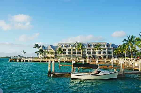 Key West: palm trees, a fishing boat, a pier and the typical skyline with the historical Key West architecture, an eclectic mix of over 3,000 wooden buildings dating from about 1886 to 1912 — Zdjęcie stockowe