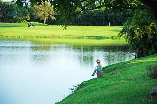 Weston, EE.UU.: la estatua de un niño pescando en un campo verde con un estanque en la comunidad suburbana planificada maestro en el condado de Broward — Foto de Stock