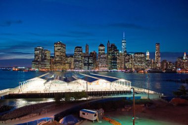 New York City, United States of America: the iconic night skyline of the city seen from the Brooklyn Heights Promenade, famous one-third of a mile long viewpoint offering breathtaking views of Manhattan and the East river clipart