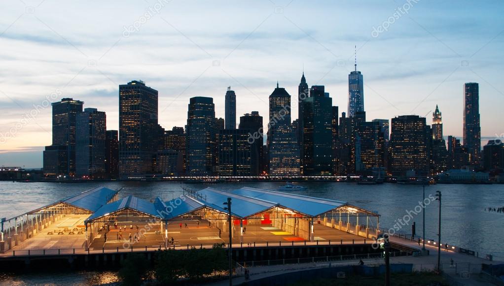 New York City, United States of America: the iconic skyline of the city seen at  sunset from the Brooklyn Heights Promenade, famous one-third of a mile long viewpoint offering breathtaking views of Manhattan and the East river