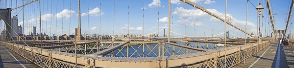 Нью-Йорк: панорамный вид на культовый Бруклинский мост, построенный в 1883 году и соединяющий районы Манхэттена и Бруклина, впадающий в Ист-Ривер — стоковое фото