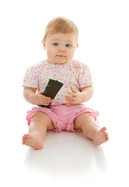 Bebê: Infantil segurando ao controle remoto da televisão — Fotografia de Stock