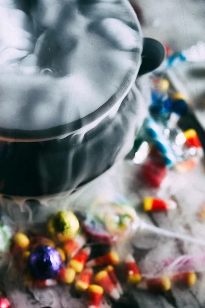 Halloween : bonbons entoure chaudron avec potion magique — Photo
