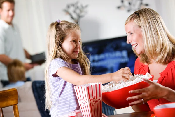 Rodina: mladí giirl bere popcorn od misky — Stock fotografie