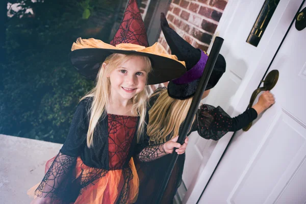 Хэллоуин: Маленькая девочка ждет, когда откроется дверь на крыльце — стоковое фото