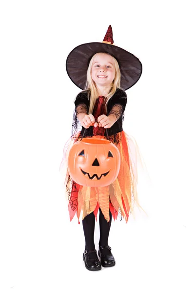 Halloween: Kleine Hexe reicht Kürbiseimer für Leckereien Stockbild
