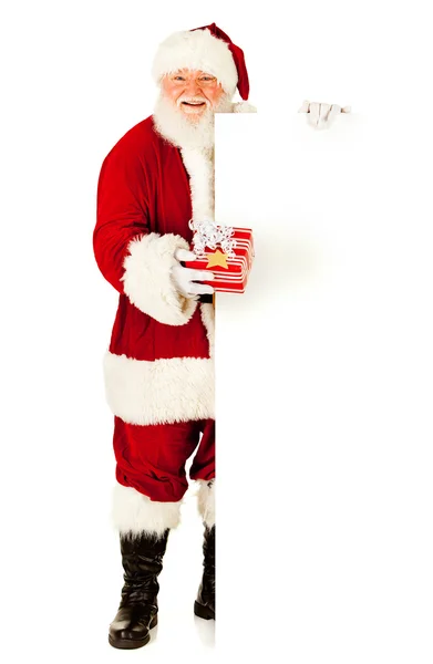 Санта: проведение Рождество подарок по белой карточке — стоковое фото