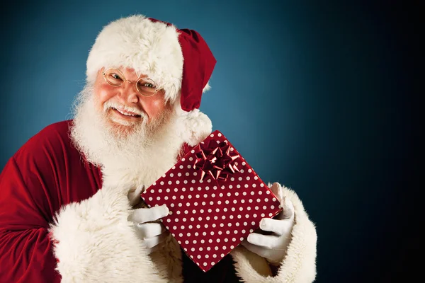 Santa: håller upp radbruten julklapp — Stockfoto