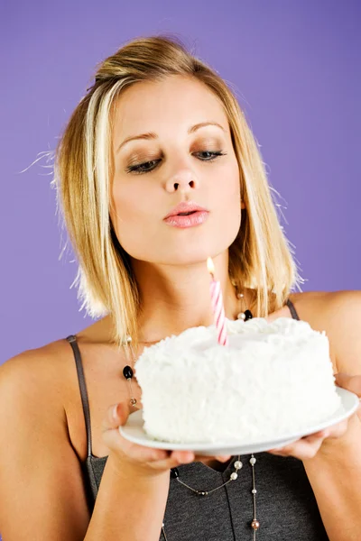 Pastel: Mujer soplando la vela en la torta de cumpleaños —  Fotos de Stock