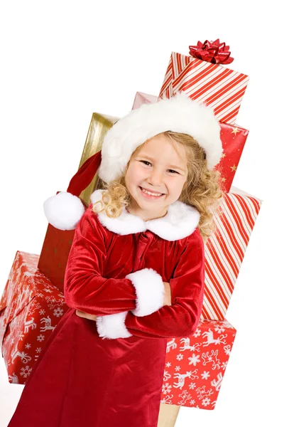 Weihnachten: kleines Mädchen vor großem Stapel verpackter Geschenke — Stockfoto