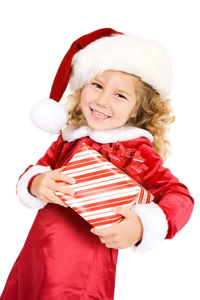 Christmas: Cute Girl In Santa Hat Carrying Gift Royalty Free Stock Photos