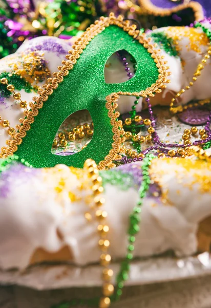 Mardi Gras: Grön Mask sitter i mitten av traditionella King kaka — Stockfoto