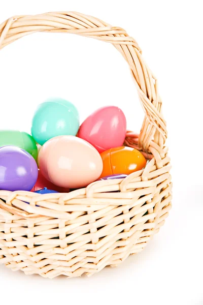 Ostern: Korb mit Plastikeiern voller Leckereien — Stockfoto