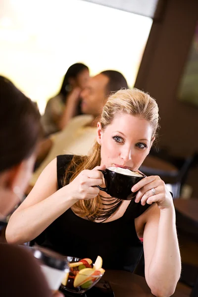 Kawy: Ładna kobieta pije kawę z bitą śmietaną — Zdjęcie stockowe