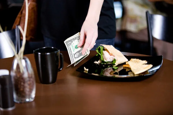 Koffie: Klant bladeren fooi op tafel — Stockfoto