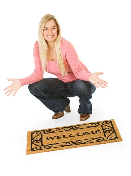 Movendo-se: mulher posando com tapete de boas-vindas — Fotografia de Stock