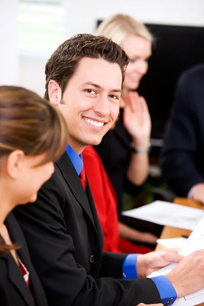 Negocio: Hombre de negocios sonriente durante la reunión — Foto de Stock
