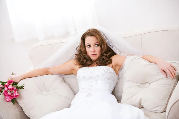 Bride: Annoyed Bride Sits On Couch with Bouquet — Stock Photo, Image