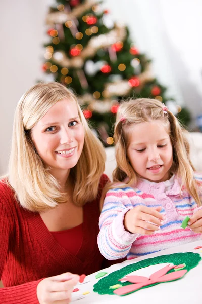 Navidad: Chica y madre trabajando en manualidades navideñas — Foto de Stock