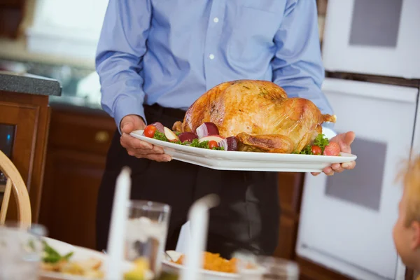 Ação de Graças: Turquia assada trazida para a mesa na platter — Fotografia de Stock