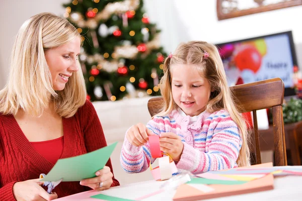 Noël : Plaisir artisanal pour la famille faisant la chaîne de papier Image En Vente
