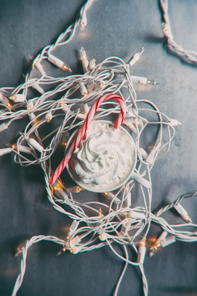 Svátek: Horké kakao sedí mezi vánoční osvětlení s Candy Cane — Stock fotografie