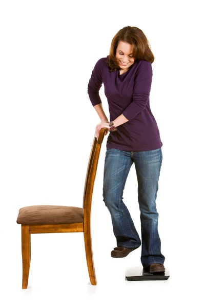Casual: Frau betrügt Waage, indem sie Stuhl hält — Stockfoto