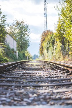 Sonbaharda terk edilmiş eski bir demiryolunun manzarası. Sıcak ışık, sürdürülebilir seyahat