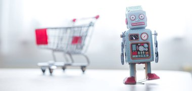 Çevrimiçi alışveriş konsepti: Oyuncak robot ve Minyatür alışveriş arabası