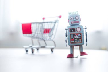 Çevrimiçi alışveriş konsepti: Oyuncak robot ve Minyatür alışveriş arabası