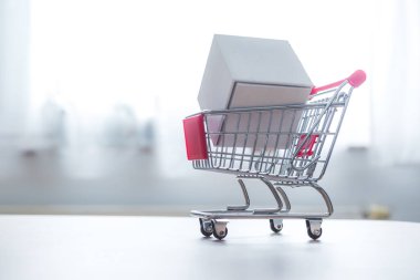 Çevrimiçi Alışveriş ve paket servis konsepti: Minyatür alışveriş arabası ve beyaz kutu