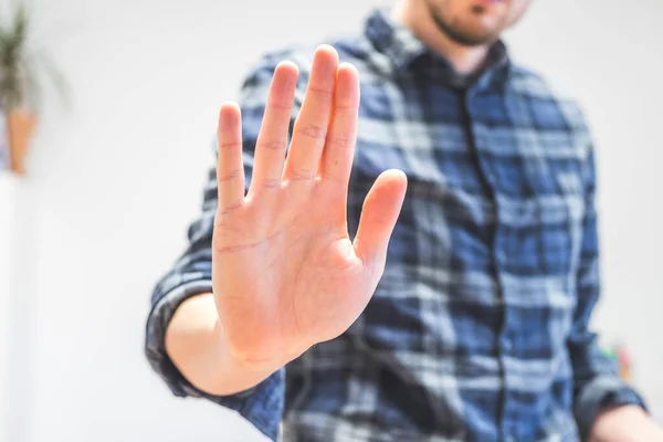 Man showing stop gesture, close up of the hand