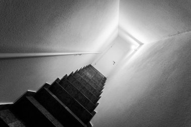 Bodrum merdivenleri, balyaları, kapalı beyaz kapılı.