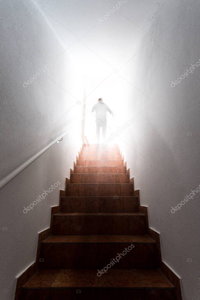 Man is going up on basement stairs with balustrade. Natural bright sunlight. 