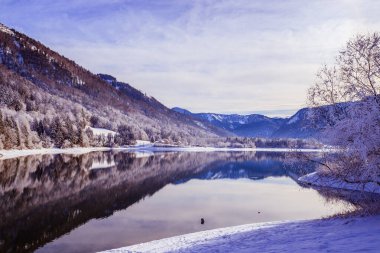 Idyllic kış manzarası: yansıma gölü, karlı ağaçlar ve dağlar